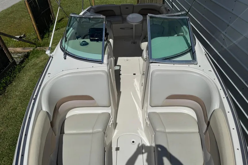 Slide: The Image of 2004 Chaparral 260 SSi boat interior with seating and windshield, parked outdoors. - 22