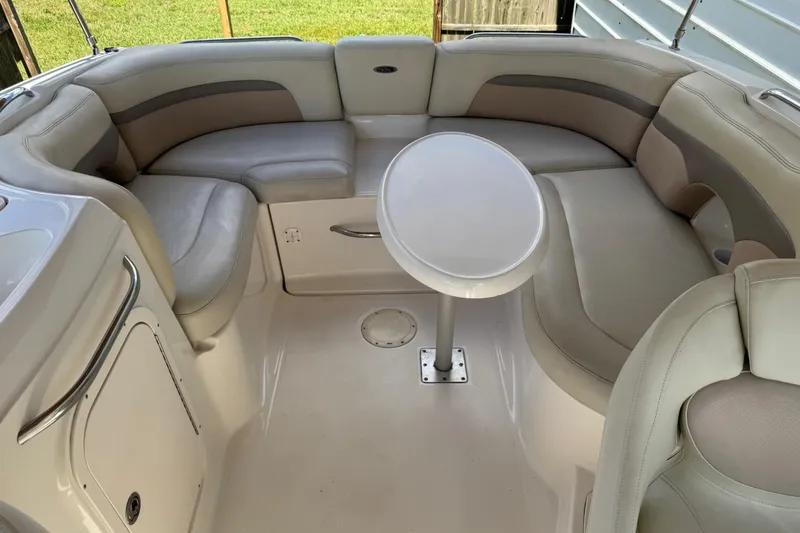 Slide: The Image of 2004 Chaparral 260 SSi boat interior with beige seating and a small round table. - 27