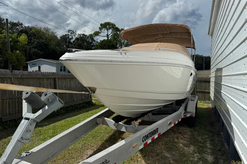 Slide: The Image of 2004 Chaparral 260 SSi boat on trailer, parked beside a building under cloudy sky. - 28