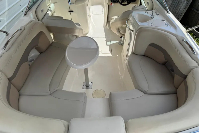 Slide: The Image of 2004 Chaparral 260 SSi boat interior with beige seating and a central table. - 6