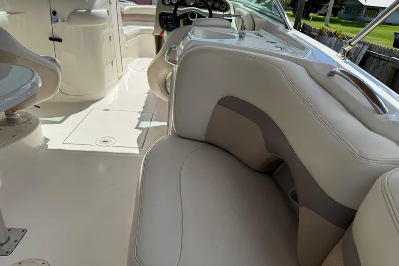 Slide: The Image of 2004 Chaparral 260 SSi boat interior with white seating and steering console. - 8