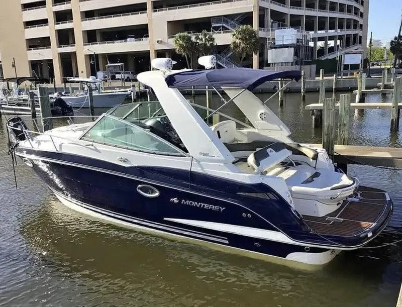 The Image of 2013 Monterey 260 SCR boat docked at marina, featuring sleek design and blue exterior. - 0