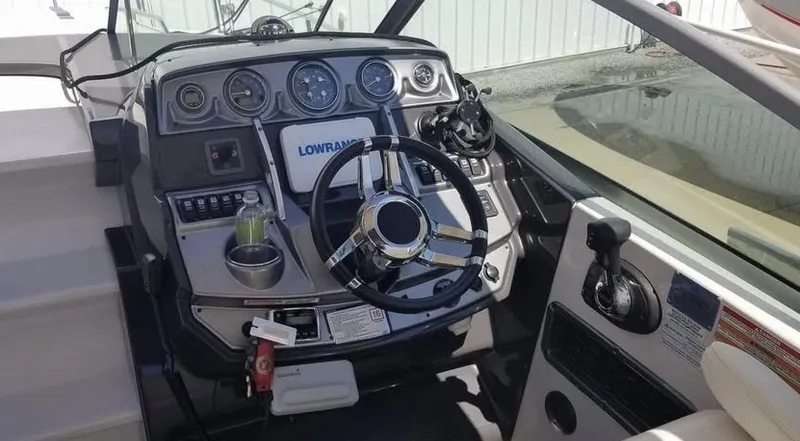 Slide: The Image of 2013 Monterey 260 SCR boat dashboard with steering wheel and navigation controls. - 14