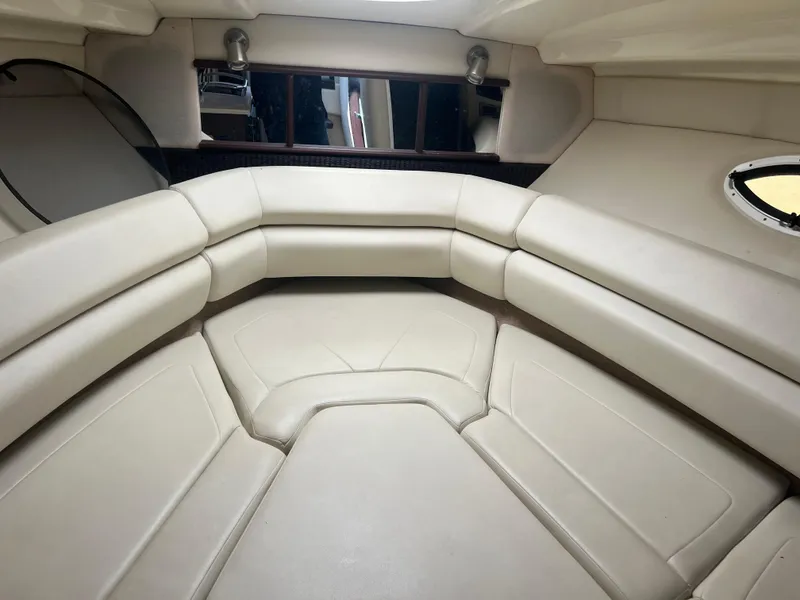 Slide: The Image of 2013 Monterey 260 SCR boat interior with beige leather seating and porthole window. - 24