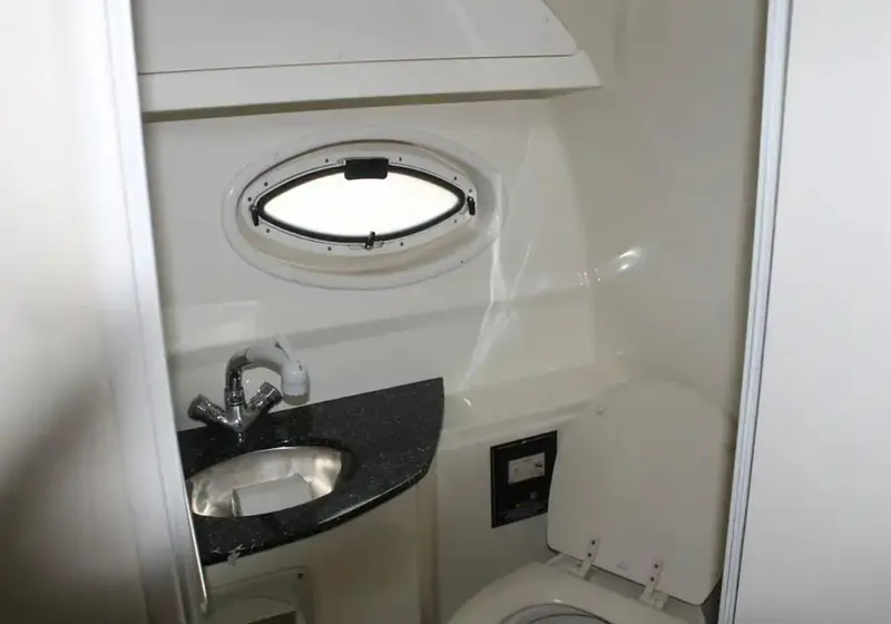 Slide: The Image of 2013 Monterey 260 SCR boat bathroom with sink, toilet, and porthole window. - 28