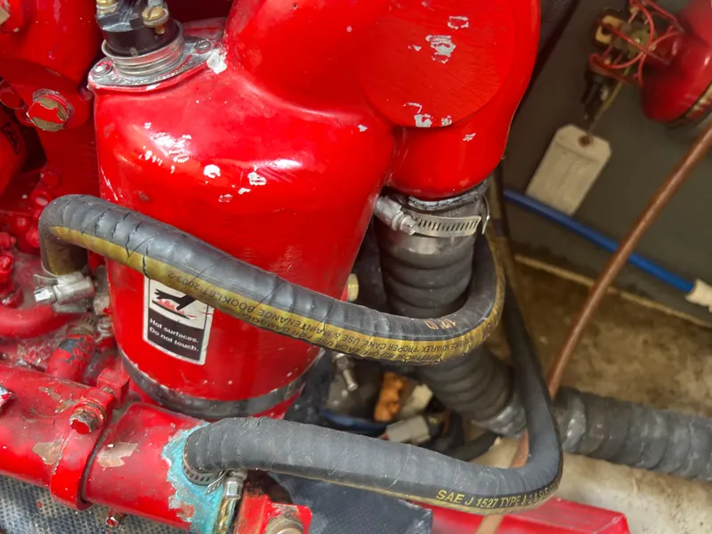Slide: The Image of Engine components of a 2013 Monterey 260 SCR boat, featuring red hoses and connectors. - 43