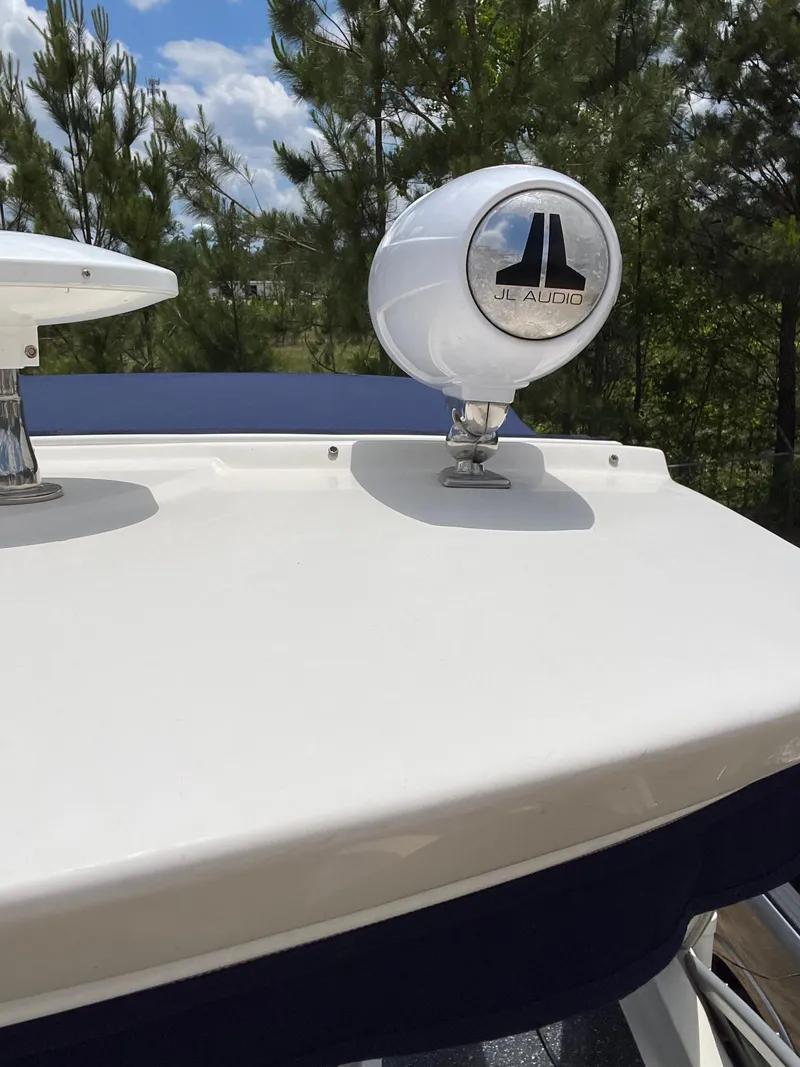 Slide: The Image of 2013 Monterey 260 SCR boat with JL Audio speaker on deck, surrounded by trees. - 9