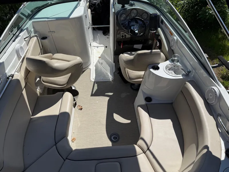 Slide: The Image of 2015 Rinker 246 Bowrider interior with beige seating, steering console, and cup holders. - 5