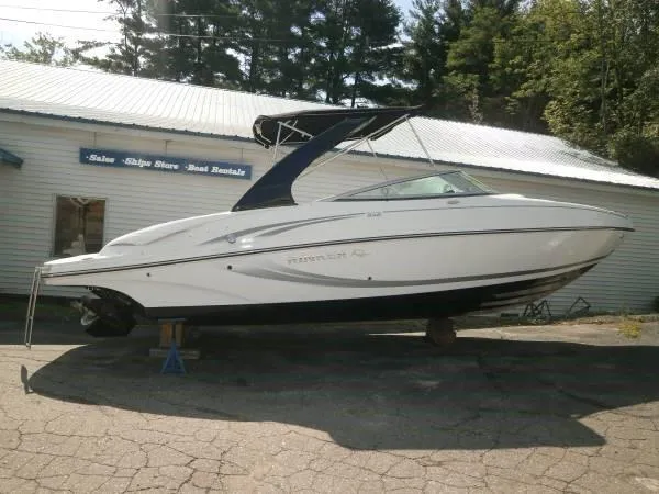The Image of 2015 Rinker 246 Bowrider boat on display outside a sales and rental shop. - 0