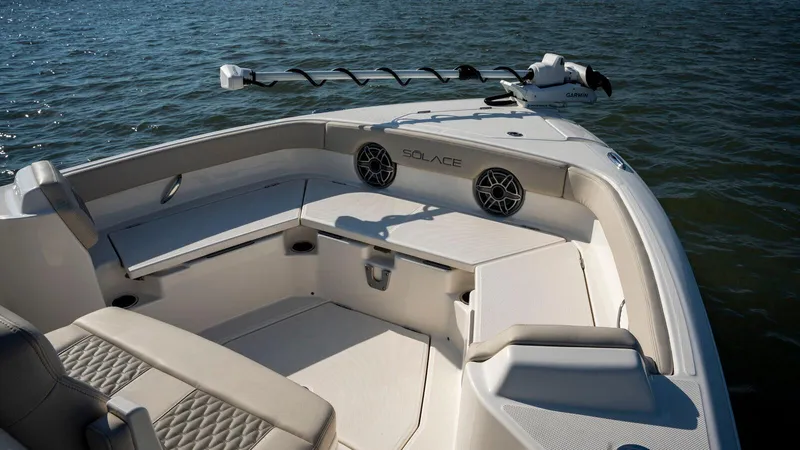 Slide: The Image of 2025 Solace 28 HCS boat interior with seating and speakers on calm water. - 6