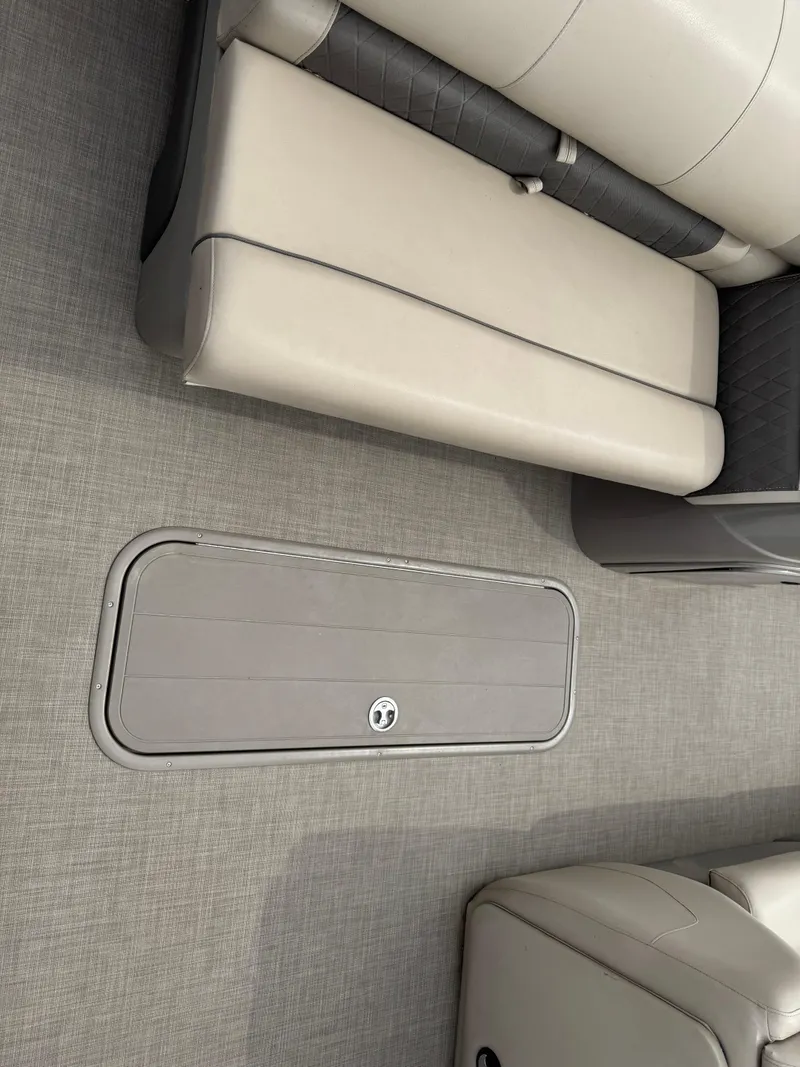 Slide: The Image of 2020 Sun Tracker Fishin' Barge 24 XP3 interior with beige seating and storage compartment. - 9