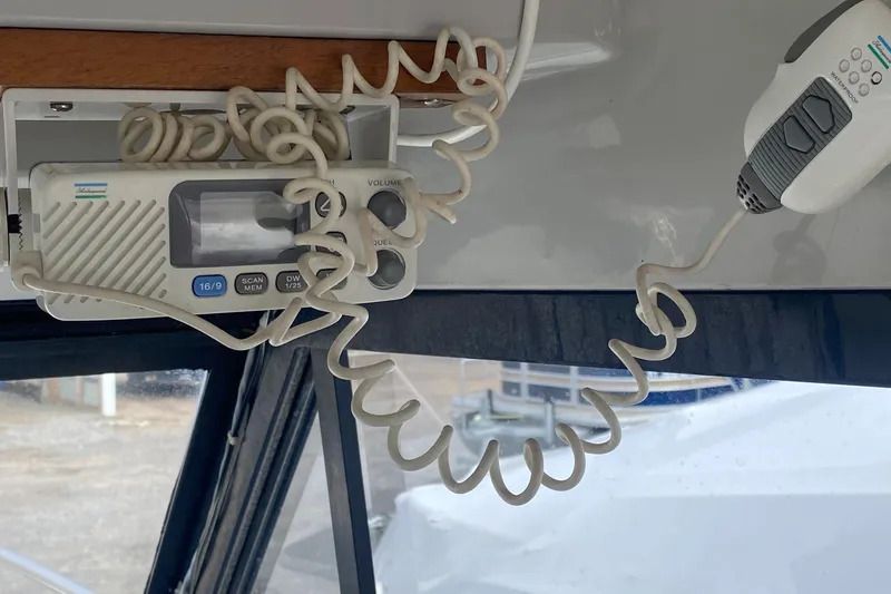 Slide: The Image of 1991 Penn Yan 215 Tempest boat interior with coiled radio handset and control panel. - 16