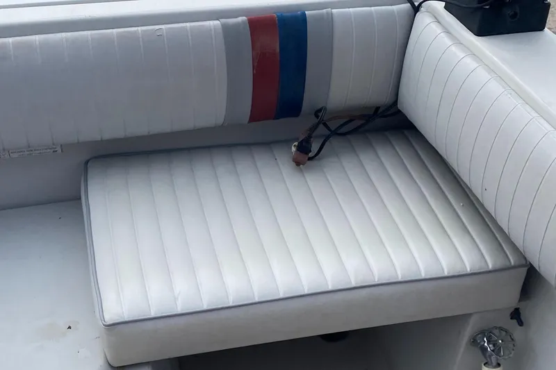 Slide: The Image of 1991 Penn Yan 215 Tempest boat interior with white cushioned seating and striped backrest. - 17