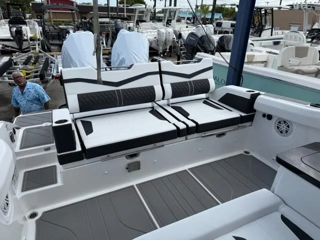 Slide: The Image of 2025 Monterey Elite 30 OB boat with sleek seating and modern design at a marina. - 12