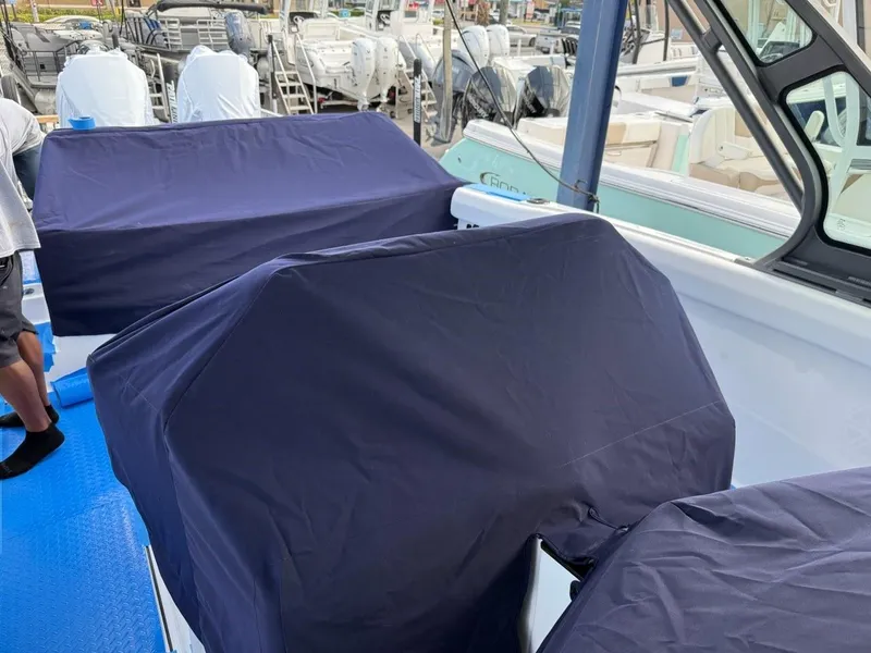 Slide: The Image of Covered outboard motors on a 2025 Monterey Elite 30 OB boat at a marina. - 15