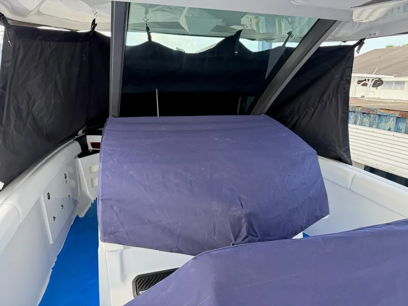 Slide: The Image of 2025 Monterey Elite 30 OB boat interior with protective covers and curtains. - 16