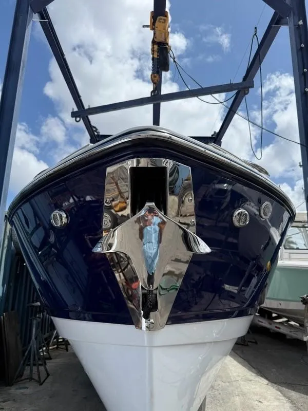Slide: The Image of 2025 Monterey Elite 30 OB boat in dry dock, viewed from the front under a blue sky. - 3