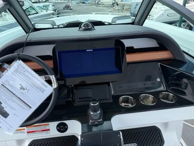 Slide: The Image of 2025 Monterey Elite 30 OB boat dashboard with steering wheel, touchscreen, and cup holders. - 8