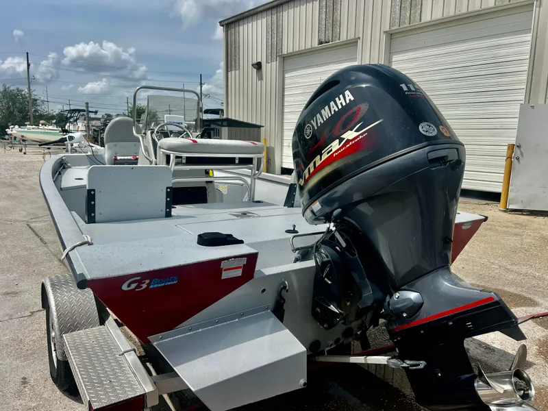 Slide: The Image of 2018 G3 Bay 18 DLX boat with Yamaha outboard motor, parked outdoors. - 10