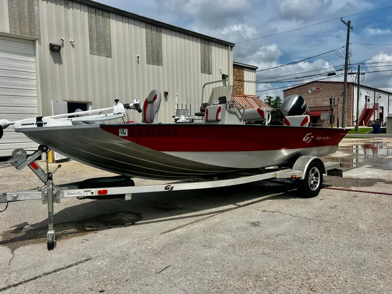 Slide: The Image of 2018 G3 Bay 18 DLX boat on trailer, parked outside industrial building. - 2