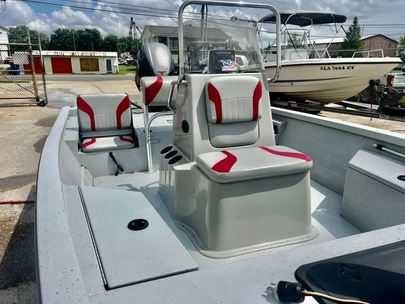 Slide: The Image of 2018 G3 Bay 18 DLX boat with red and gray seating, docked outdoors. - 3