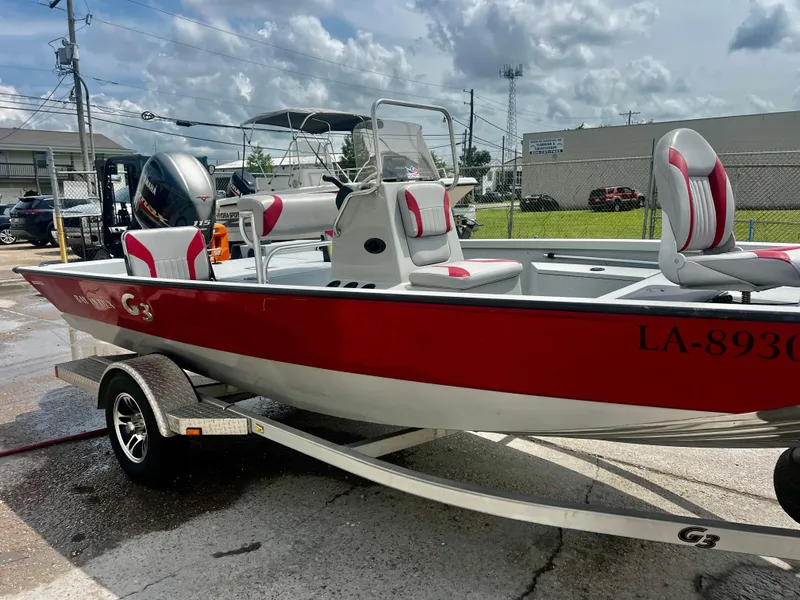 Slide: The Image of 2018 G3 Bay 18 DLX boat on trailer, red and white design, parked outdoors. - 7