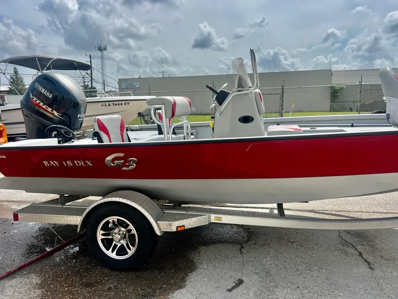 Slide: The Image of 2018 G3 Bay 18 DLX boat on trailer, red and white design, Yamaha motor. - 8