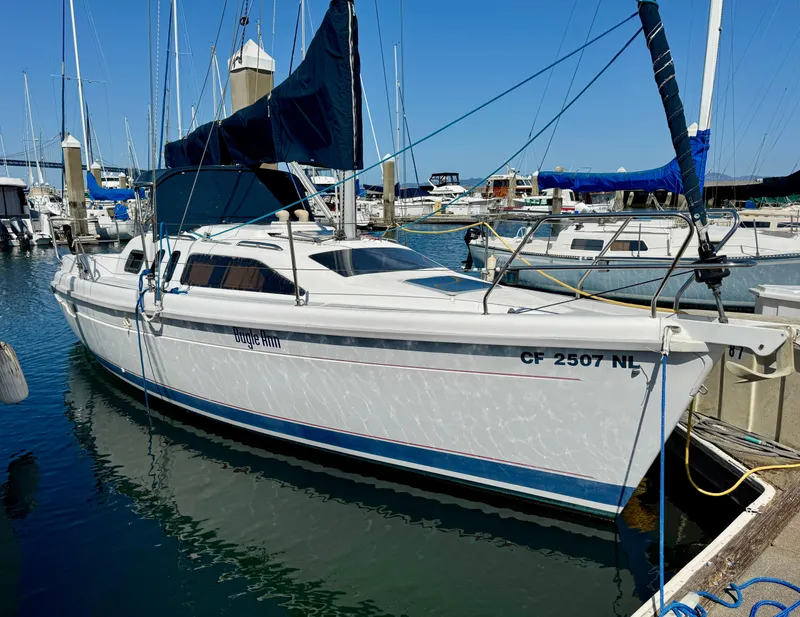 The Image of 1994 Hunter 29.5 sailboat docked in marina, featuring sleek white hull and blue accents. - 1