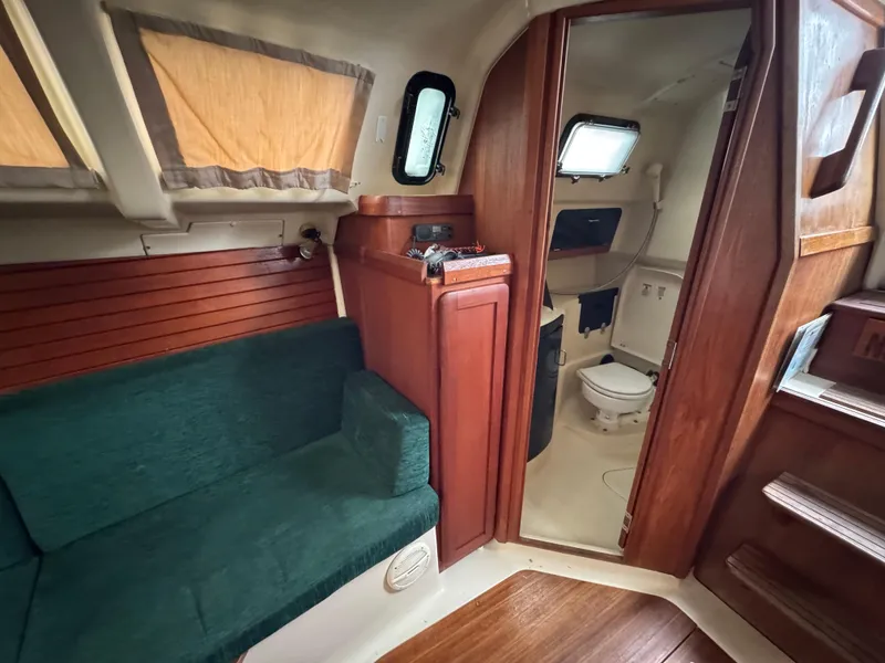 Slide: The Image of Interior of 1994 Hunter 29.5 sailboat with green seating and wooden cabinetry. - 10