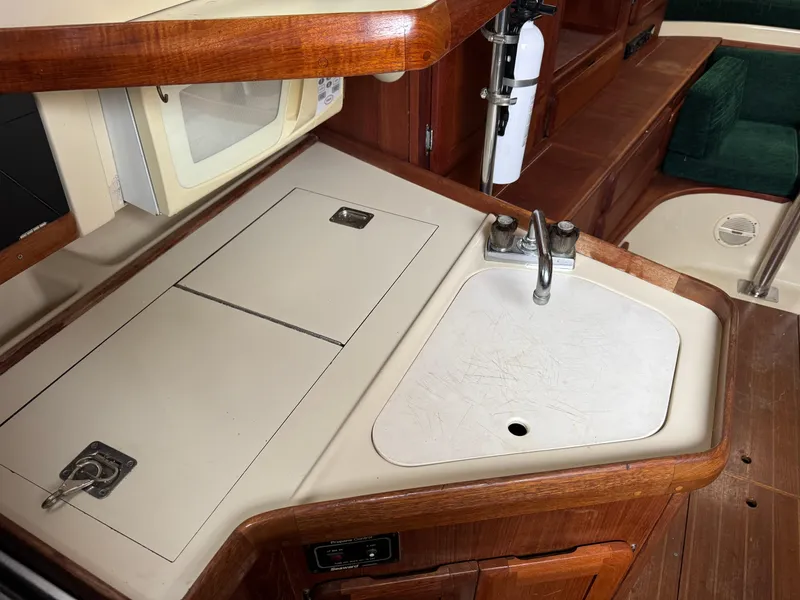 Slide: The Image of 1994 Hunter 29.5 yacht interior kitchen with sink and wooden cabinetry. - 13
