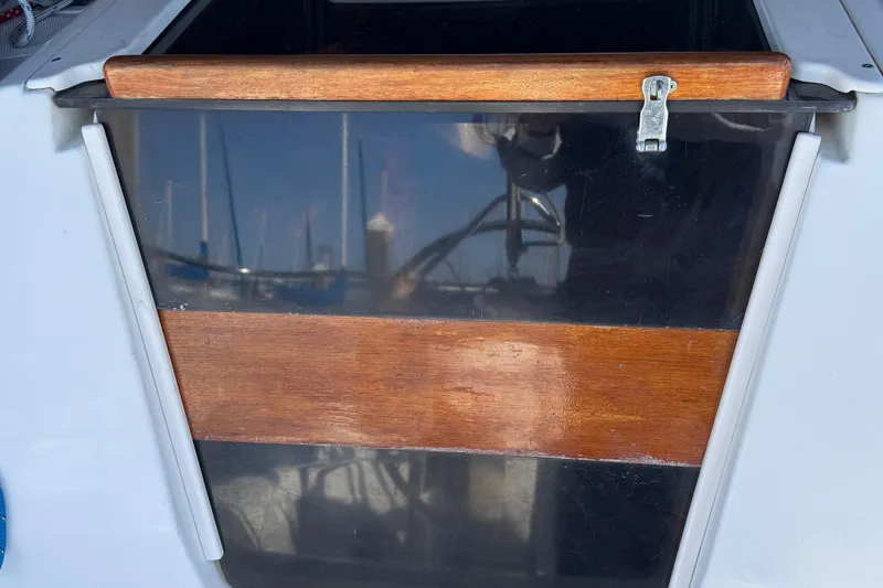 Slide: The Image of Wooden hatch door on a 1994 Hunter 29.5 sailboat, with marina reflections. - 22
