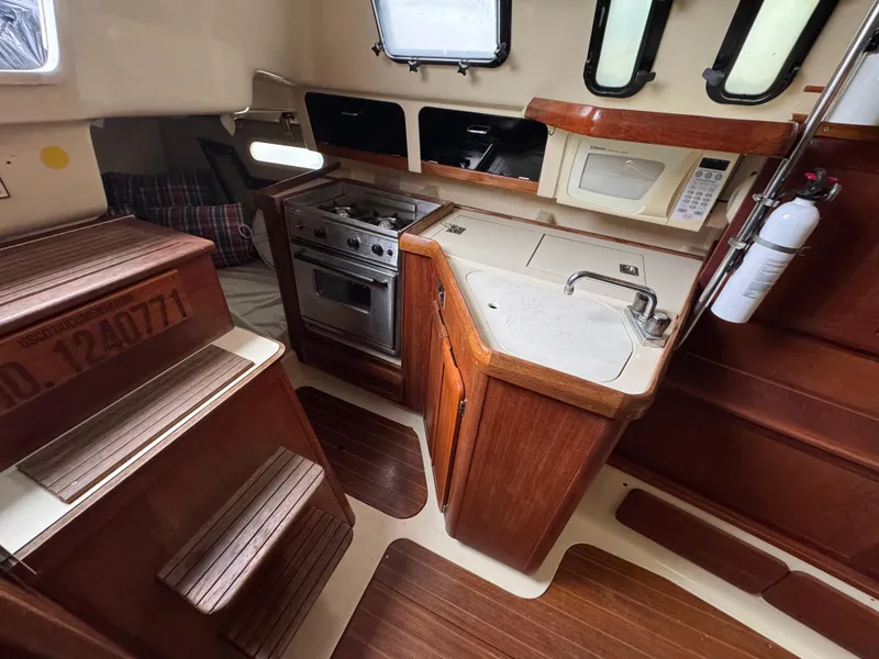 Slide: The Image of Interior of a 1994 Hunter 29.5 sailboat with kitchen and wooden cabinetry. - 4
