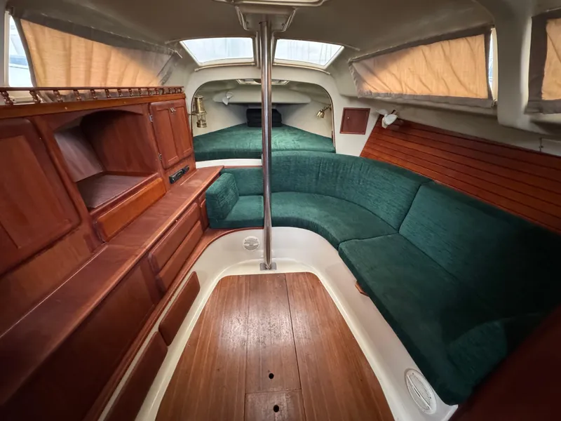Slide: The Image of 1994 Hunter 29.5 sailboat interior with green seating and wooden cabinetry. - 6