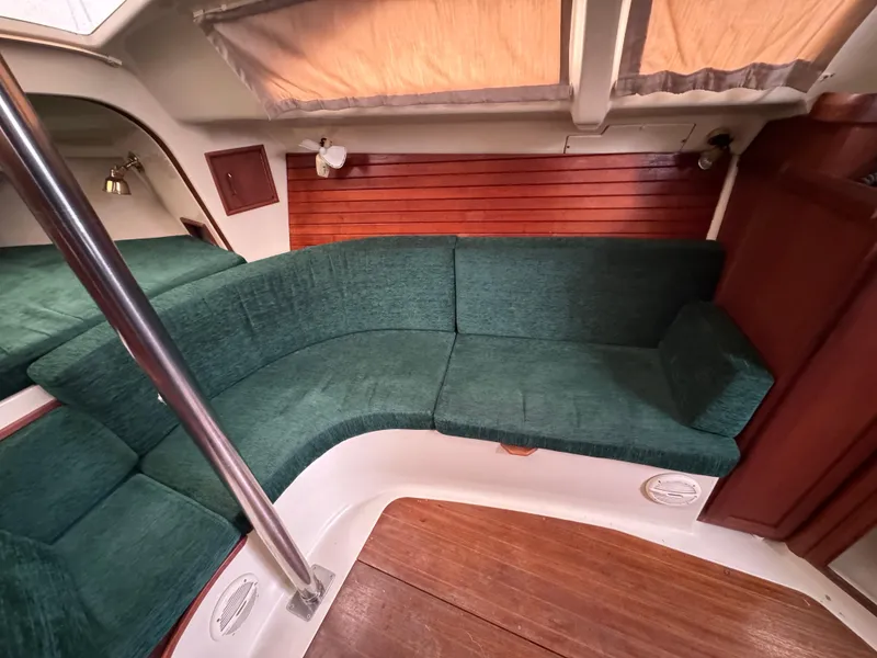 Slide: The Image of Interior of a 1994 Hunter 29.5 sailboat with green seating and wood accents. - 7
