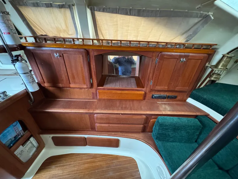 Slide: The Image of 1994 Hunter 29.5 sailboat interior with wooden cabinets and green seating. - 8