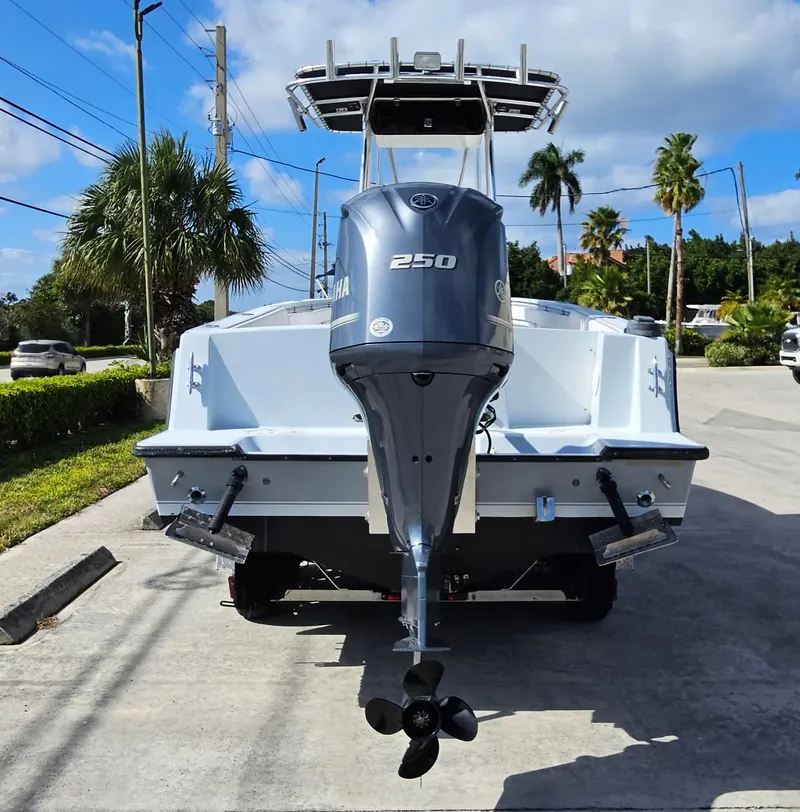 Slide: The Image of 2002 Contender 23 Open boat with Yamaha 250 engine, parked on a sunny street. - 11