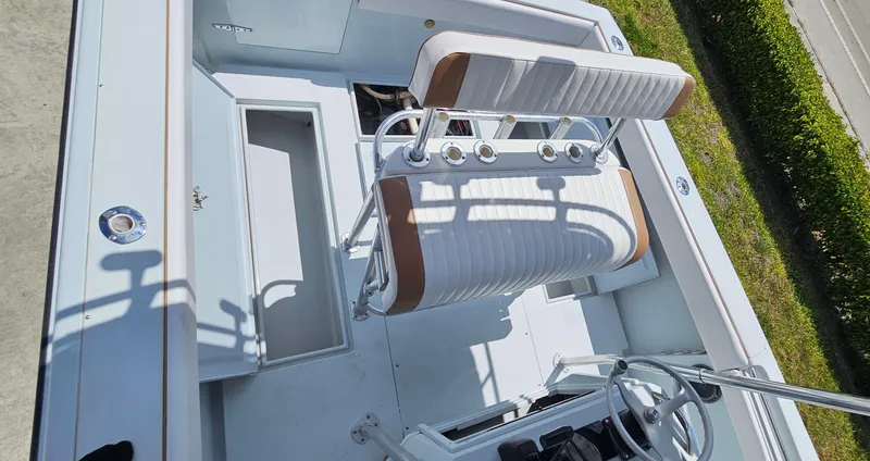 Slide: The Image of 2002 Contender 23 Open boat interior with white seating and steering wheel. - 15