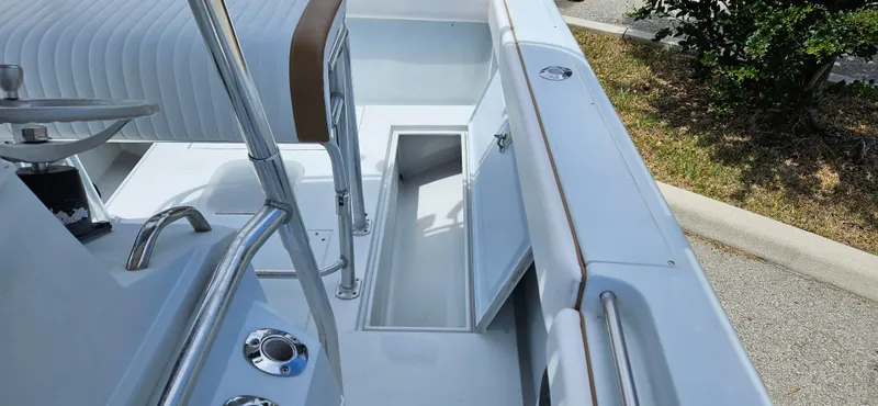 Slide: The Image of 2002 Contender 23 Open boat interior with storage compartment and seating. - 18