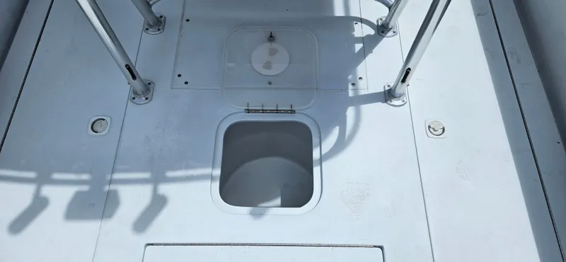 Slide: The Image of 2002 Contender 23 Open boat deck with storage hatch and metal supports. - 20