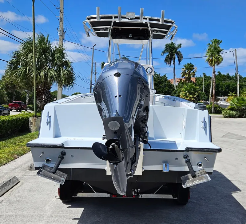Slide: The Image of 2002 Contender 23 Open boat with outboard motor, parked on a sunny day. - 6