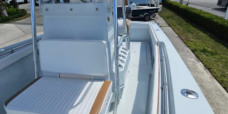 Slide: The Image of 2002 Contender 23 Open boat with white seating and sleek design, docked outdoors. - 7