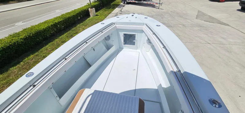 Slide: The Image of 2002 Contender 23 Open boat, spacious deck view, sleek design, parked on concrete. - 8