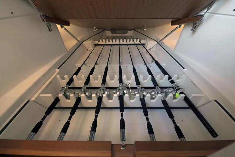 Slide: The Image of Storage compartment with organized fishing rods in a 2025 Solace 37 CS boat. - 15