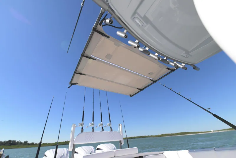 Slide: The Image of 2025 Solace 37 CS boat with fishing rods and retractable sunshade on a sunny day. - 9