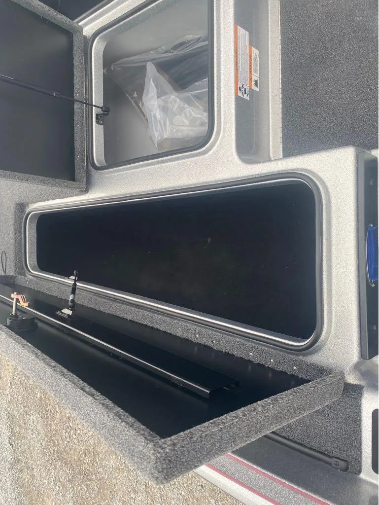 Slide: The Image of 2024 Triton 179 TrX boat storage compartments, open and empty, showcasing interior space. - 12