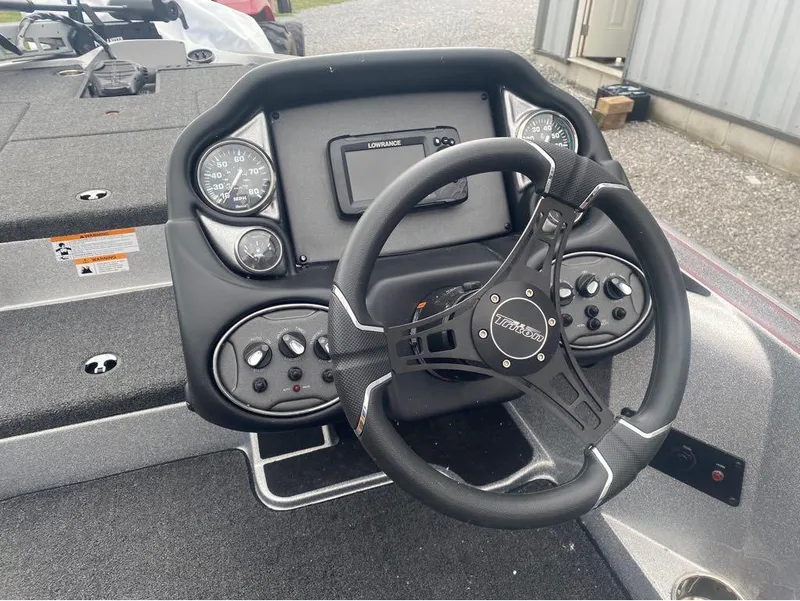 Slide: The Image of 2024 Triton 179 TrX boat dashboard with steering wheel and gauges. - 5