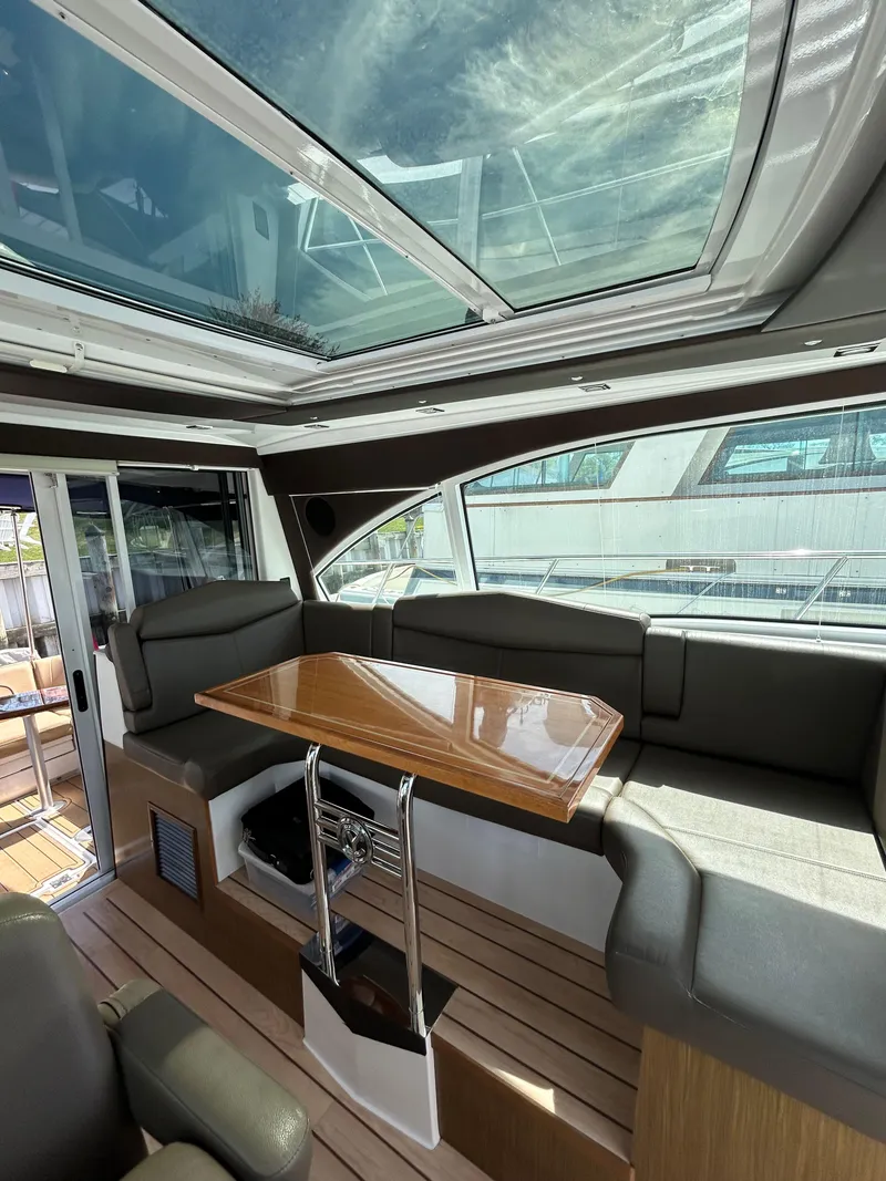 Slide: The Image of 2014 Cruisers Yachts 41 Cantius interior with skylight, sleek seating, and wooden table. - 10
