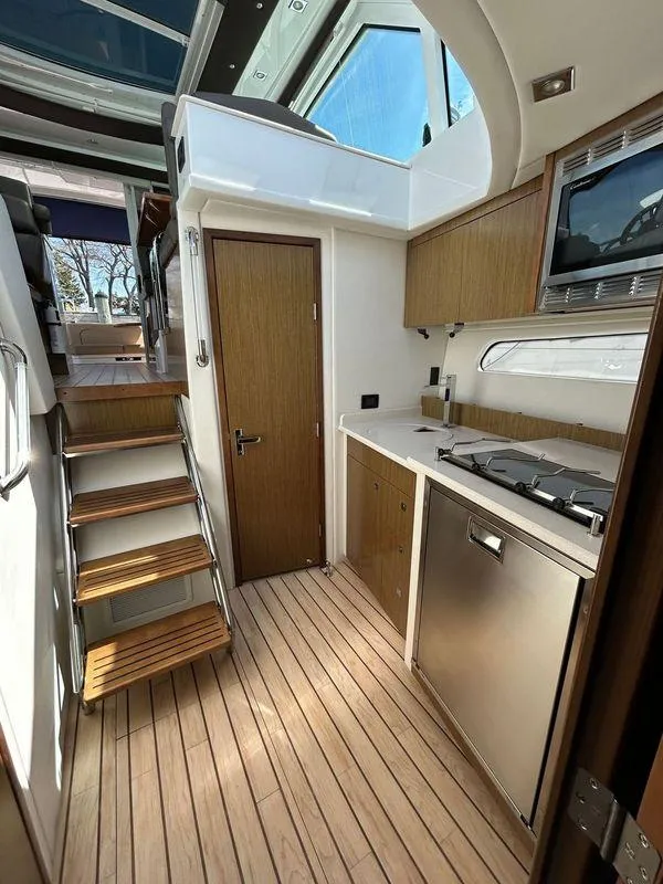Slide: The Image of 2014 Cruisers Yachts 41 Cantius interior with modern kitchen and wooden flooring. - 16