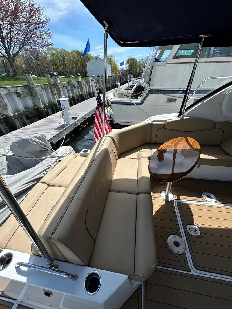 Slide: The Image of 2014 Cruisers Yachts 41 Cantius with beige seating and wooden table, docked at marina. - 5