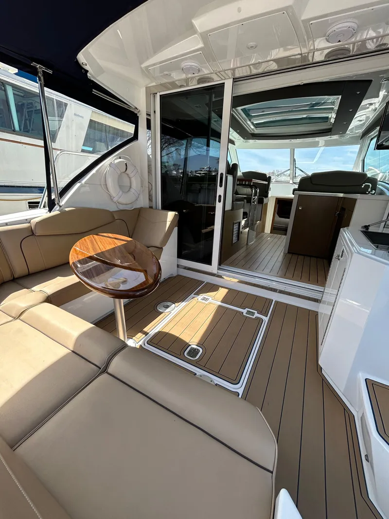 Slide: The Image of 2014 Cruisers Yachts 41 Cantius interior with tan seating and wooden accents. - 6